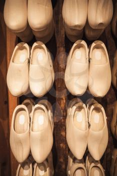 Uncolored new clogs made of poplar wood hanging in souvenir shop. Klompen are traditional Dutch shoes for everyday use