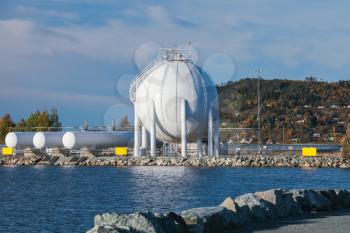 White spherical gas holder stands on sea coast in Stjordal, Norway
