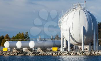 Modern white spherical gas holder stands on sea coast near Trondheim airport, close-up photo