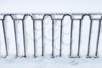 Forged black fence covered with snow, Griboedov canal coast, Saint Petersburg, Russia in winter