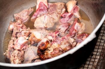 Lamb pieces stew in a cauldron. Preparing of Chorba soup on open fire, traditional meal for many national cuisines in Europe, Africa and Asia 