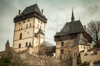 Karlstejn castle exterior. Vintage toned photo. Gothic castle founded 1348 CE by Charles IV, Holy Roman Emperor-elect and King of Bohemia. Karlstejn village, Czech Republic