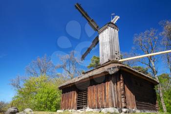 Old wooden windmill under blue sky,  rural Swedish landscape