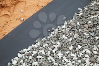 Geotextile layer between gravel and sandy ground
