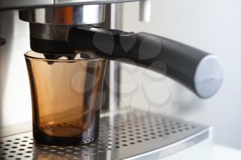 Empty dark glass cup in espresso coffee machine