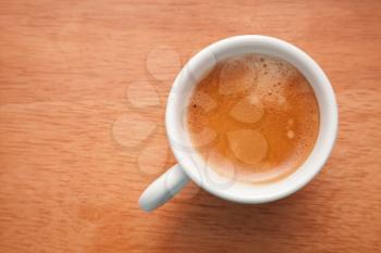 Small espresso cup. Top view on wooden table background