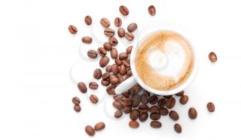 Small cup of cappuccino with coffee beans and heart shaped milk foam, top view isolated on white background