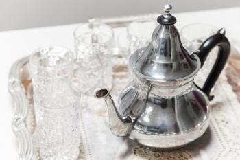 Moroccan tea theme. Shining metal teapot with glasses