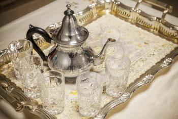 Arabic tea theme. Teapot with glasses on metal salver