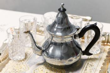 Arabic tea theme. Metal teapot with glasses on salver