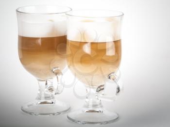 Two glass mugs with handles of latte coffee