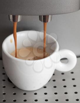 White ceramic cup in coffee machine. Espresso preparing