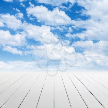 White wooden floor with perspective and cloudy sky