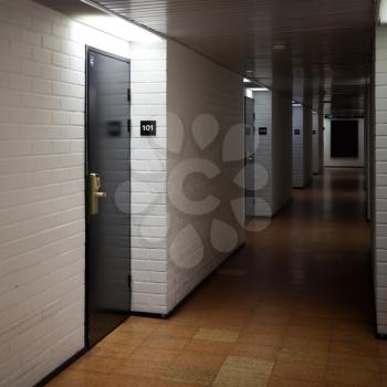 Abstract dark hotel corridor interior with doors and room numbers
