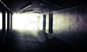 Abstract dark underground corridor interior with glowing end