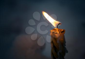 Closeup photo of little candle flame in the dark