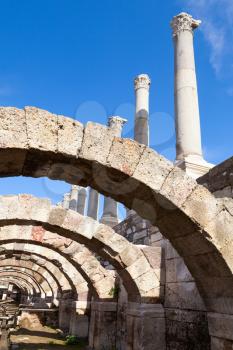 Ancient columns and arches on blue sky background, fragment of ruined roman temple in Smyrna. Izmir, Turkey