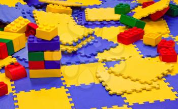 Background with multicolored plastic toy bricks and carpets