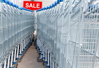 Supermarket shopping carts with SALE text label on a background