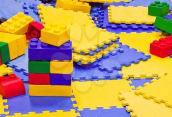 Background with multicolored plastic toy bricks and carpets