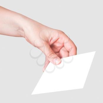 Female hand with the white card on gray background