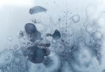 Male face print on frozen windows glass