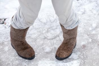 Dancing male feet with traditional Russian felt boots on winter snowy road