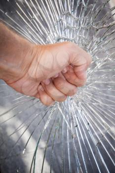 Strong male fist with broken window glass