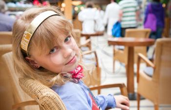 Portrait of a little blond girl in cafe
