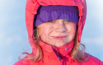little ruddy nice girl in winter outwear with hood smiles