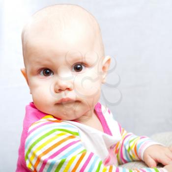 Little brown eyed baby pursed her lips. Сloseup studio portrait