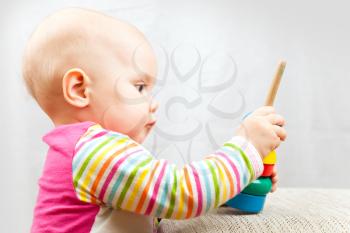 Little baby plays with wooden toy
