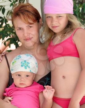 Outdoor summer family portrait of Young Caucasian mother and two her children