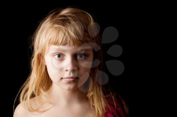 Closeup studio portrait of blond Caucasian little girl on black background