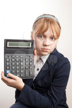 Little blond schoolgirl with calculator above white