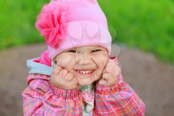 Funny laughing Caucasian baby girl in pink