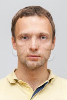 Closeup studio face portrait of young Caucasian ordinary man isolated on gray background