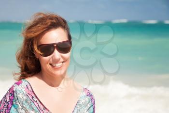 Young beautiful Caucasian woman in sunglasses. Summer outdoor portrait on the ocean coast