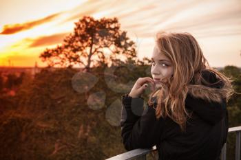 Outdoor stylized portrait of teenage Caucasian blond girl with evening sunlight, tonal correction filter effect