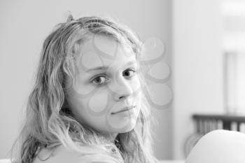 Blond teenage girl closeup monochrome indoor portrait with natural light