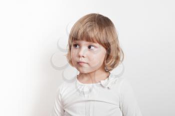Little blond Caucasian girl over white background, studio portrait
