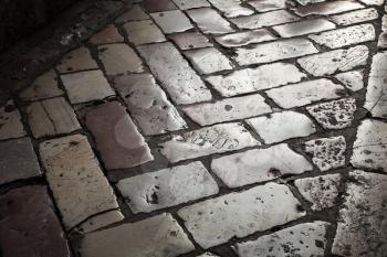 Old shining stone pavement on dark street