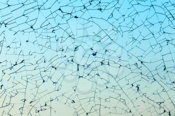 Broken glass texture with cracks over blue background