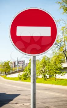 Round red road sign on metal pole. No Entry road-sign mounted on urban roadside