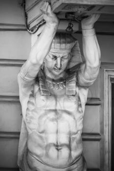 Atlas as decorative column element of the facade of an old classical building in Saint-Petersburg, Russia. Black and white