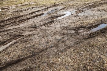 Dirty road with puddles and mud, countryside transportation background