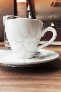 White coffee cup on saucer. Closeup photo with selective focus and vintage tonal correction photo filter, old instagram style effect