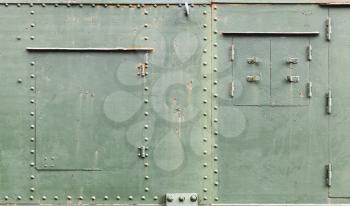Abstract green industrial metal background texture with manholes, bolts and rivets, details of Russian armored train from WWII time