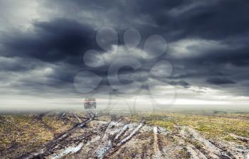 Dirty rural road with puddles and mud under dark dramatic stormy sky, SUV car goes far away, transportation background