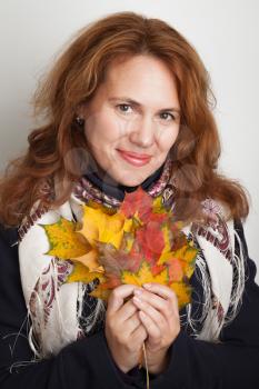 Portrait of beautiful smiling Young Caucasian woman with colorful autumn maple leaves